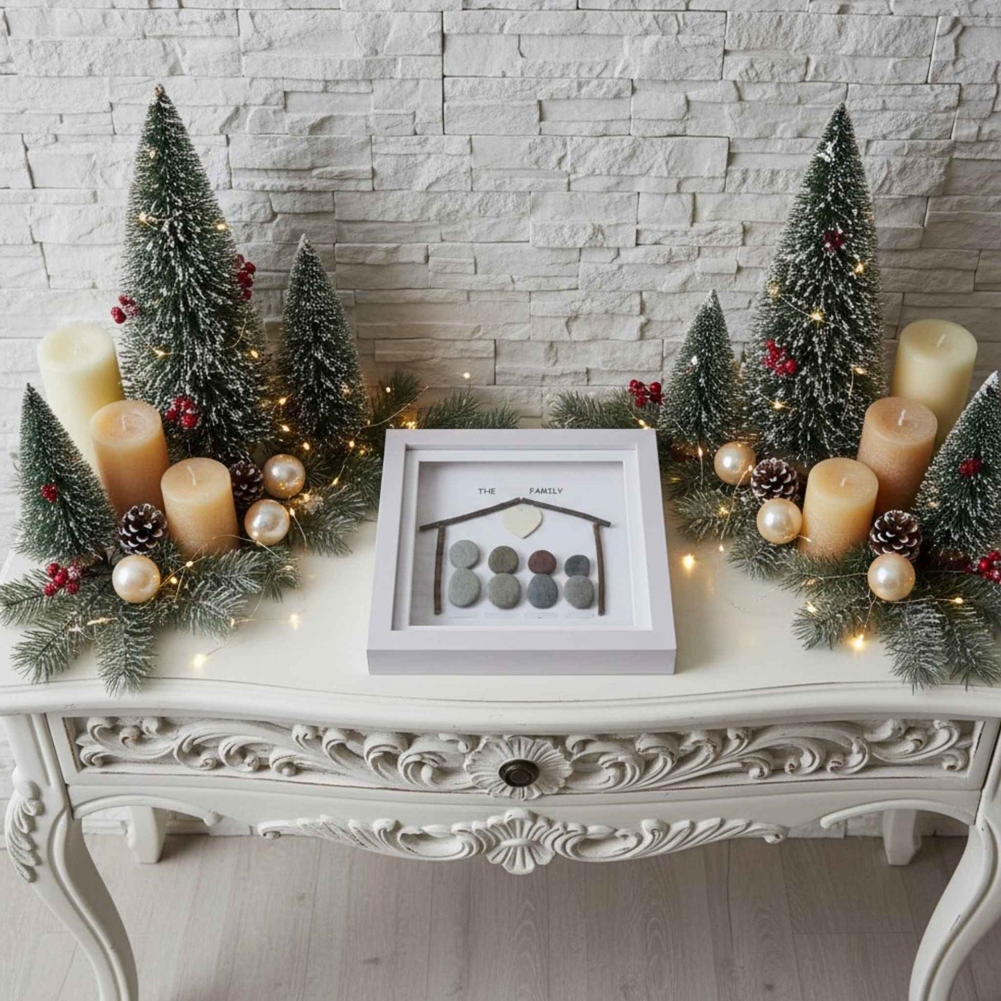 Ariel view of pebble art on a console table surrounded by Christmas decorations.