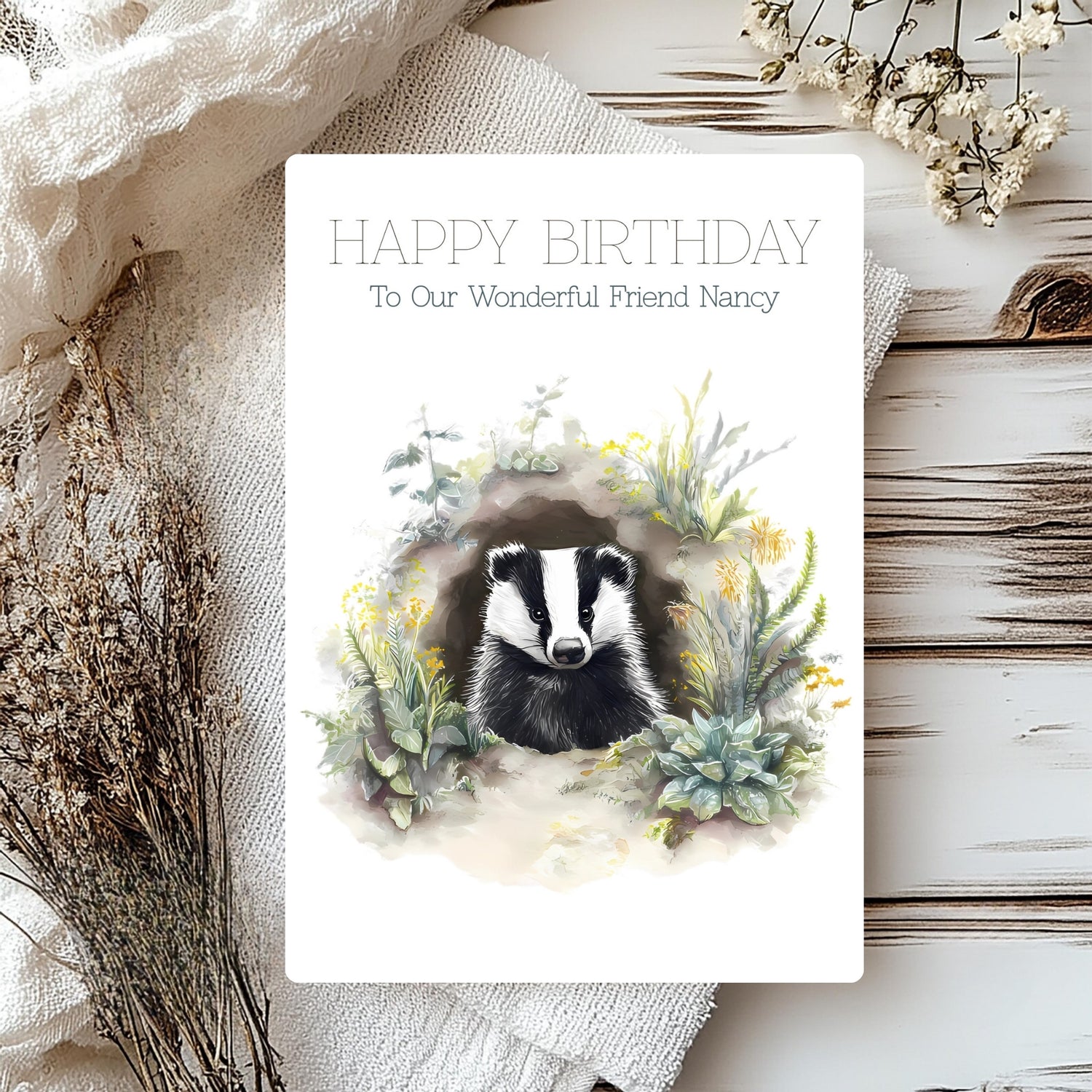 Birthday card with badger illustration and floral wreath on a rustic background
