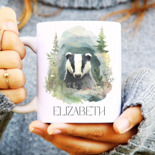 Person holding a mug with a badger illustration and the name 'ELIZABETH'.