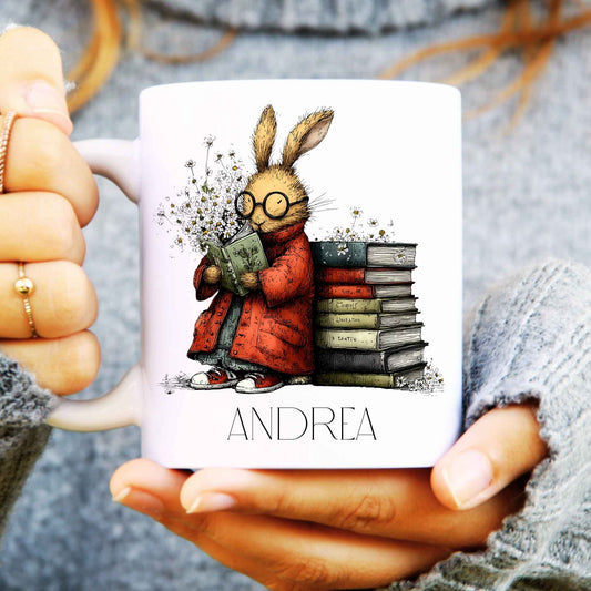Person holding a mug with a hare illustration and 'ANDREA' text