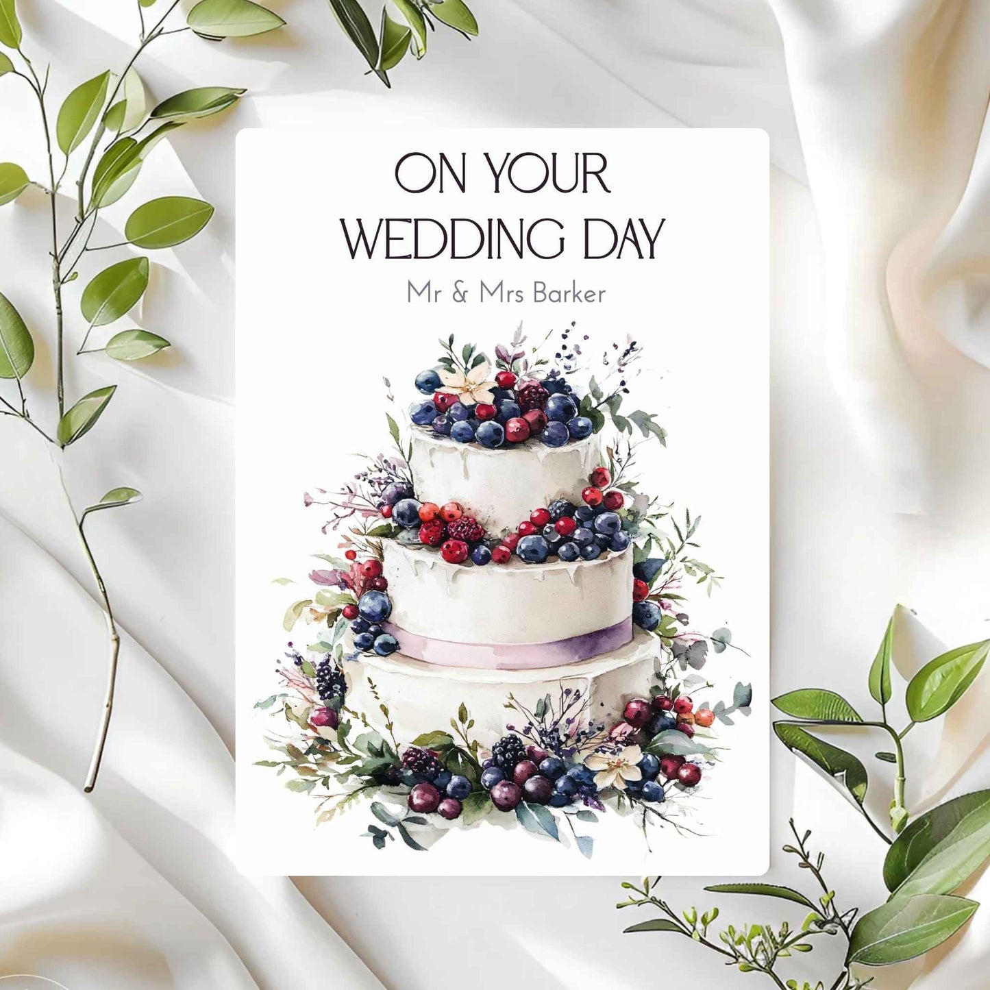 Wedding card with a cake illustration and 'On Your Wedding Day' text on a white background with green leaves.