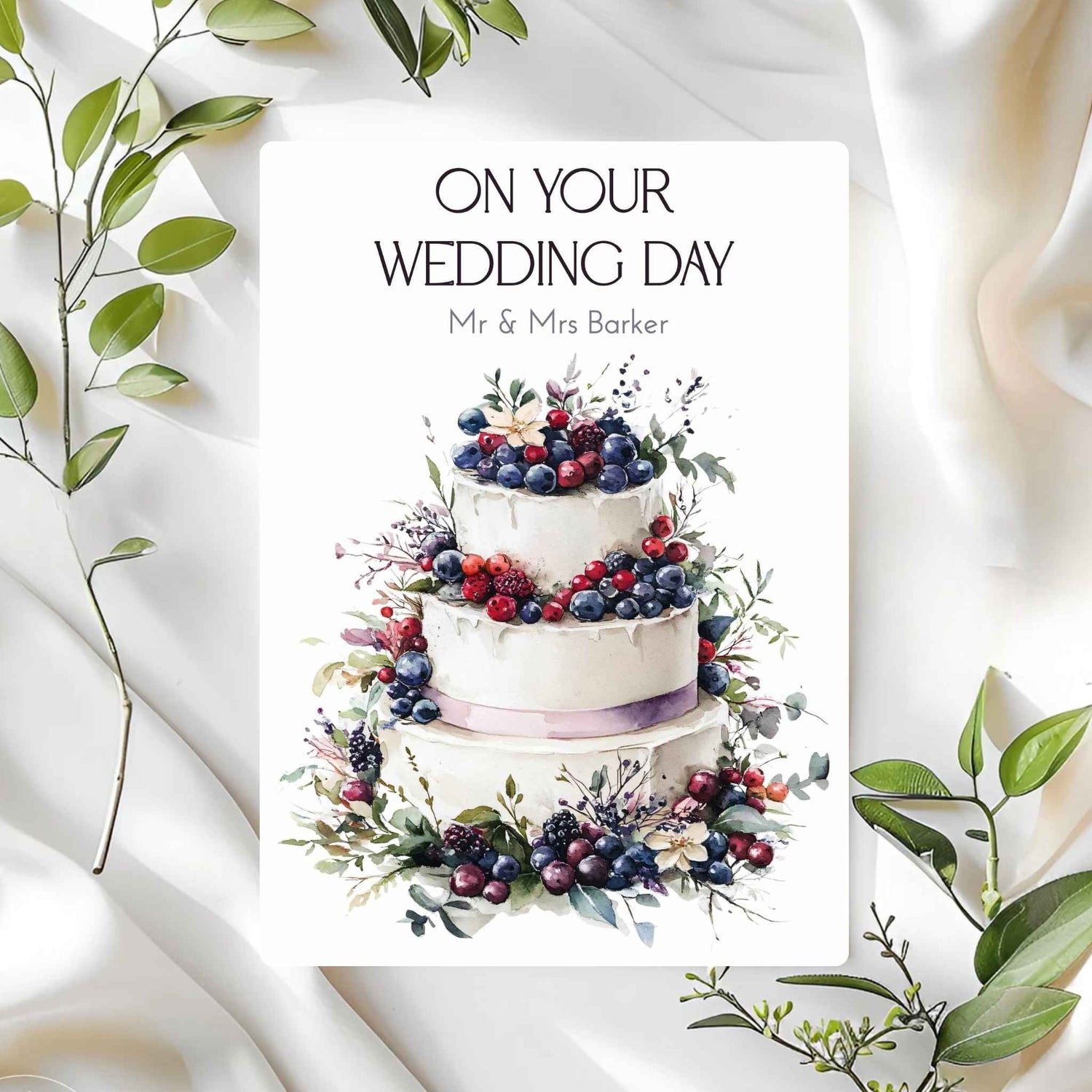 Wedding card with a cake illustration and 'On Your Wedding Day' text on a white background with green leaves.