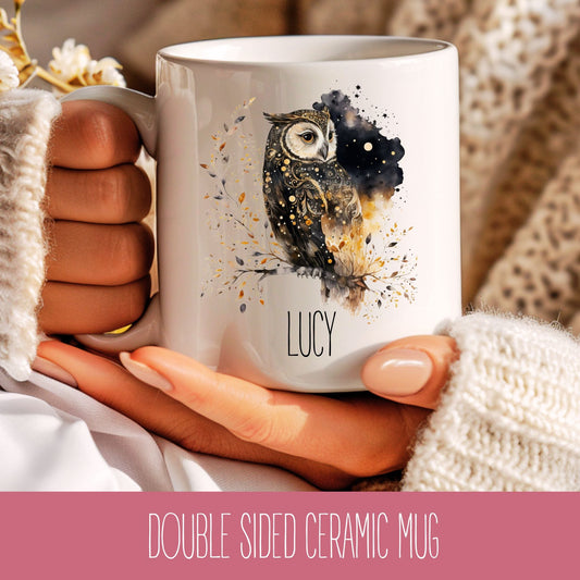 A personalised ceramic coffee mug with a celestial owl design and the name 'Lucy' printed on the side, held in a person's hand.