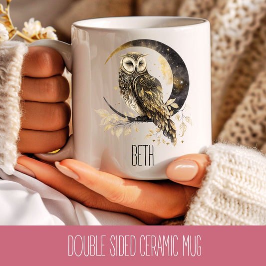 A personalised ceramic mug with a celestial owl design and the name 'Beth' printed on the side, held in a person's hand.