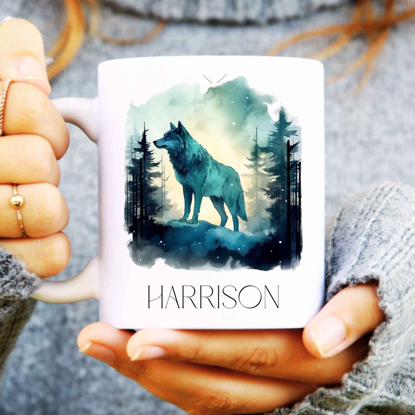 Person holding a mug with a wolf design and 'HARRISON' text