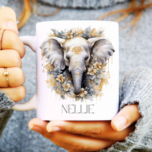 Person holding a mug with an elephant design and the name 'NELLIE'.
