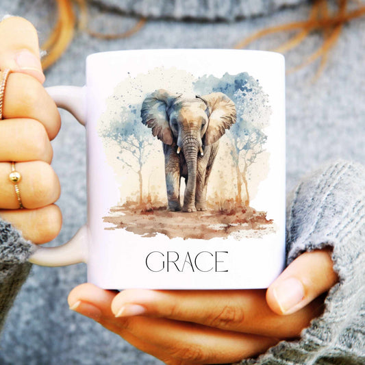 Person holding a mug with an elephant design and the word 'GRACE' on it.