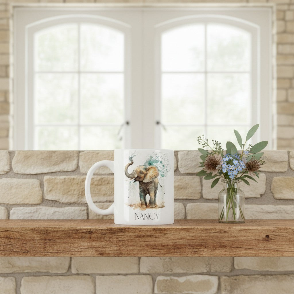 White ceramic mug with an elephant design on a wooden ledge with a mini vase of flowers.