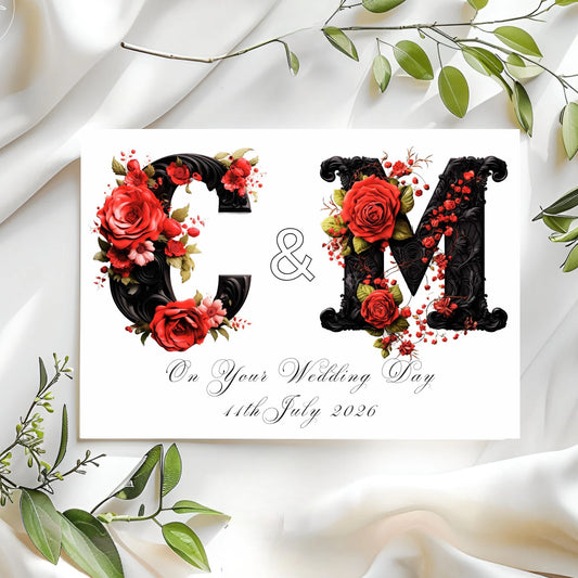Gothic wedding card with floral initials 'GM' and green leaves on a white fabric background