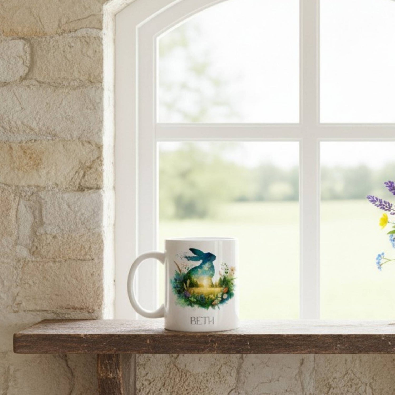 Mug with a hare design on a windowsill next to a stone wall