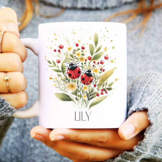 White mug with floral and ladybug design held by a person