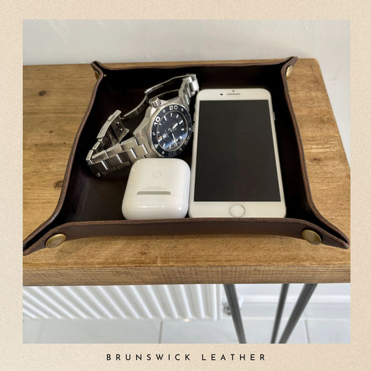 Leather tray with phone, watch, and device on a wooden surface with 'Brunswick Leather' branding.