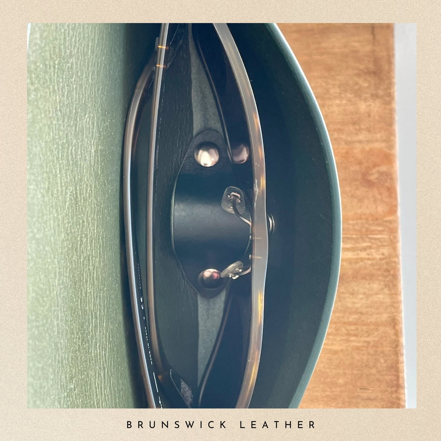 Close-up of a leather product with 'Brunswick Leather' branding on a wooden surface.