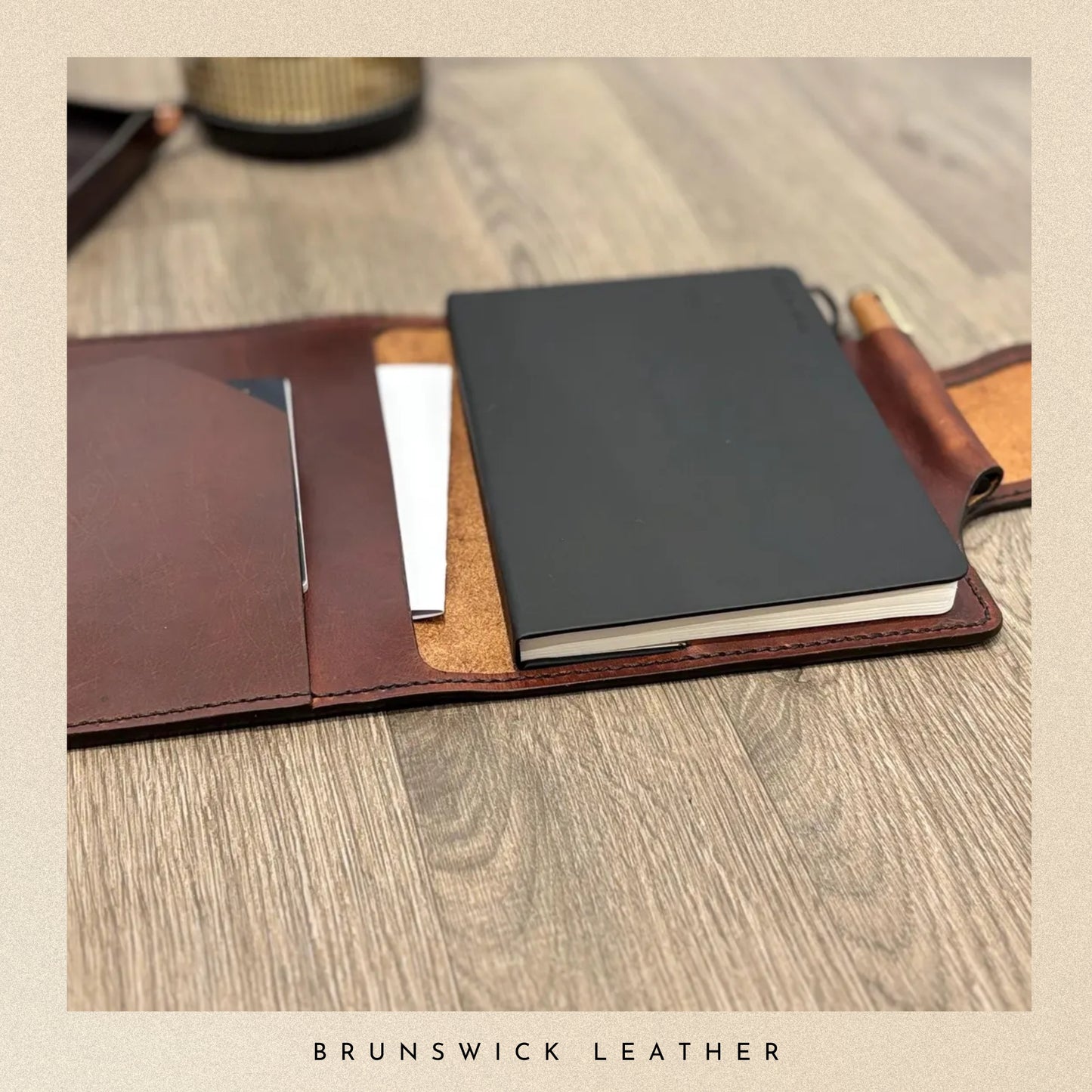 Leather-bound notebooks on a wooden surface with 'Brunswick Leather' branding.