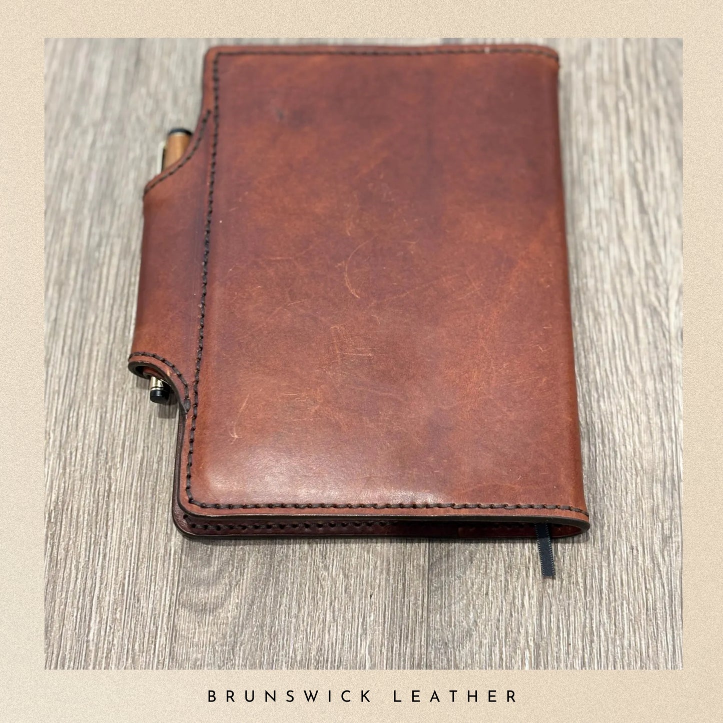 Brown leather notebook on a wooden surface with 'Brunswick Leather' branding.
