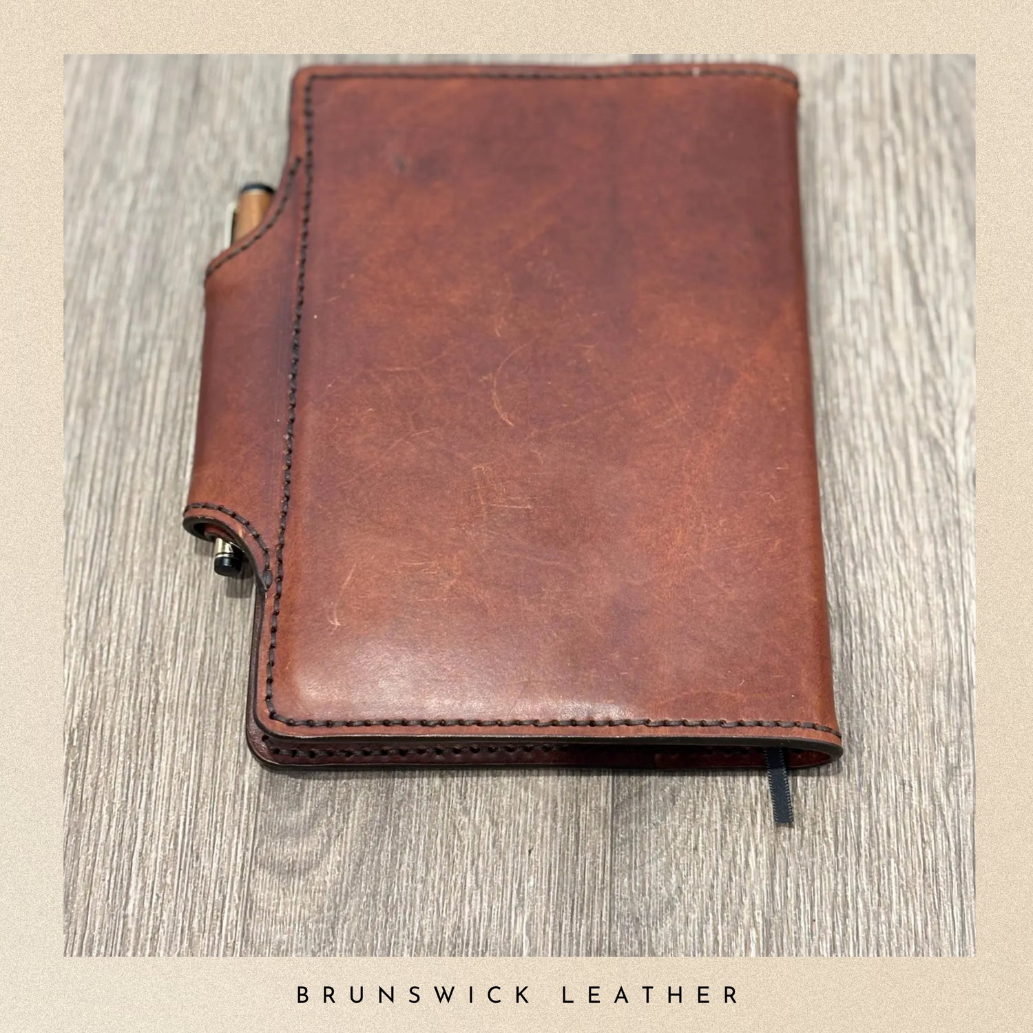 Brown leather notebook on a wooden surface with 'Brunswick Leather' branding.