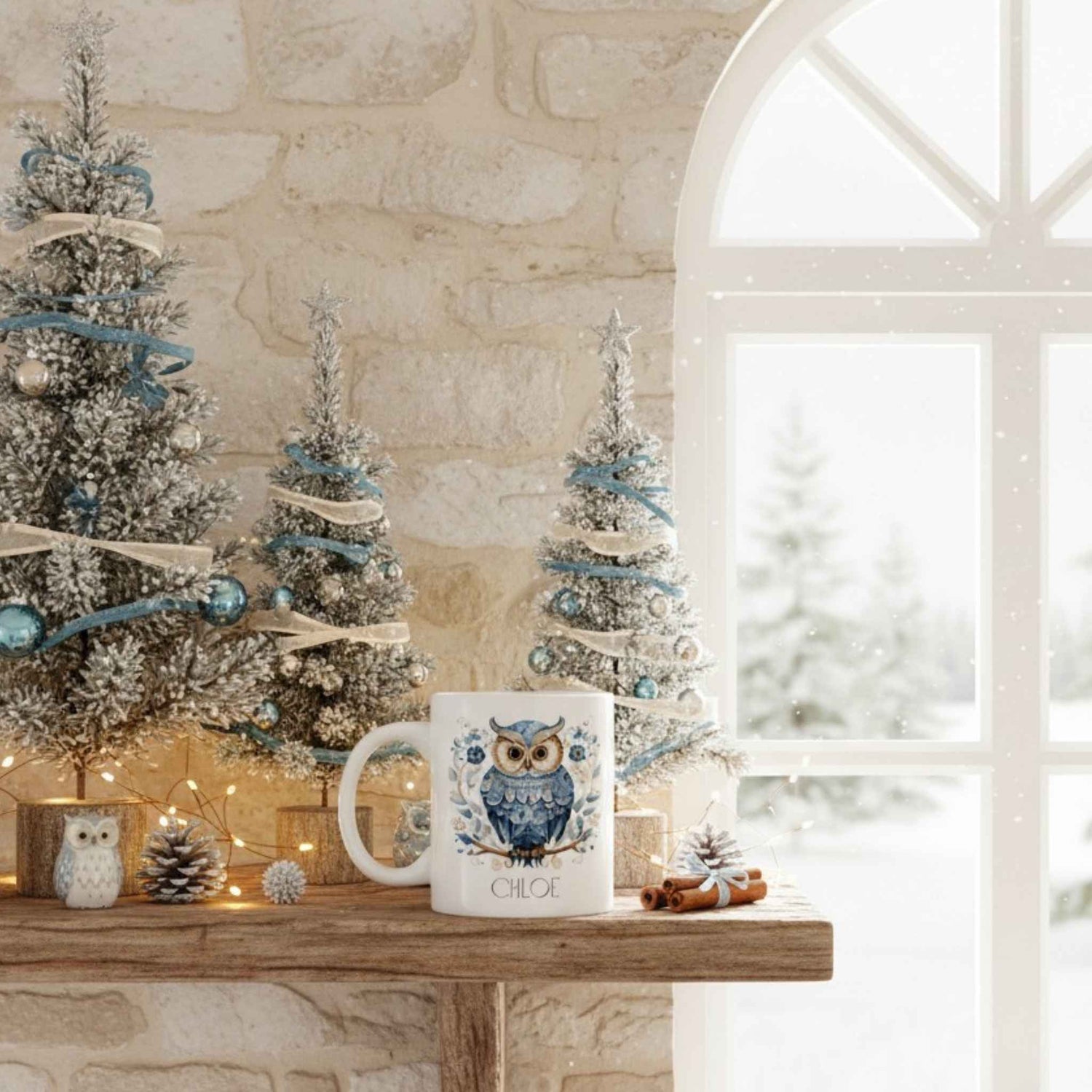 Decorative scene with small Christmas trees and a mug featuring an owl design on a stone fireplace.