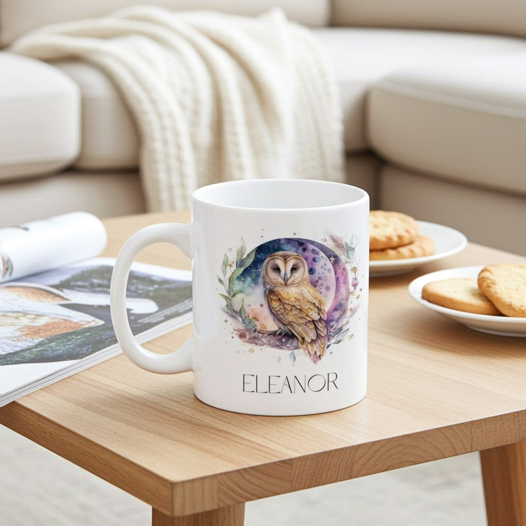 White mug with owl design and 'Eleanor' text on a wooden table with cookies and a magazine.