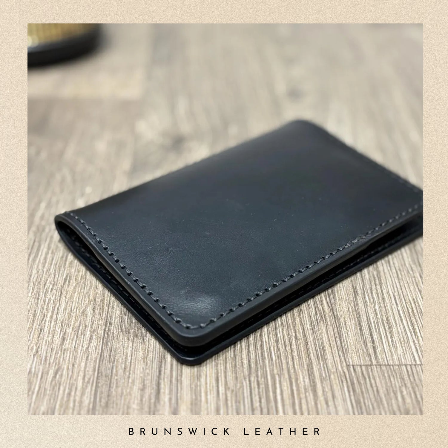 Blue leather wallet on a wooden surface with 'Brunswick Leather' branding.