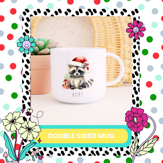A white double-sided mug with a printed raccoon design wearing a Santa hat, positioned on a table with a wreath in the background, surrounded by colourful flowers.