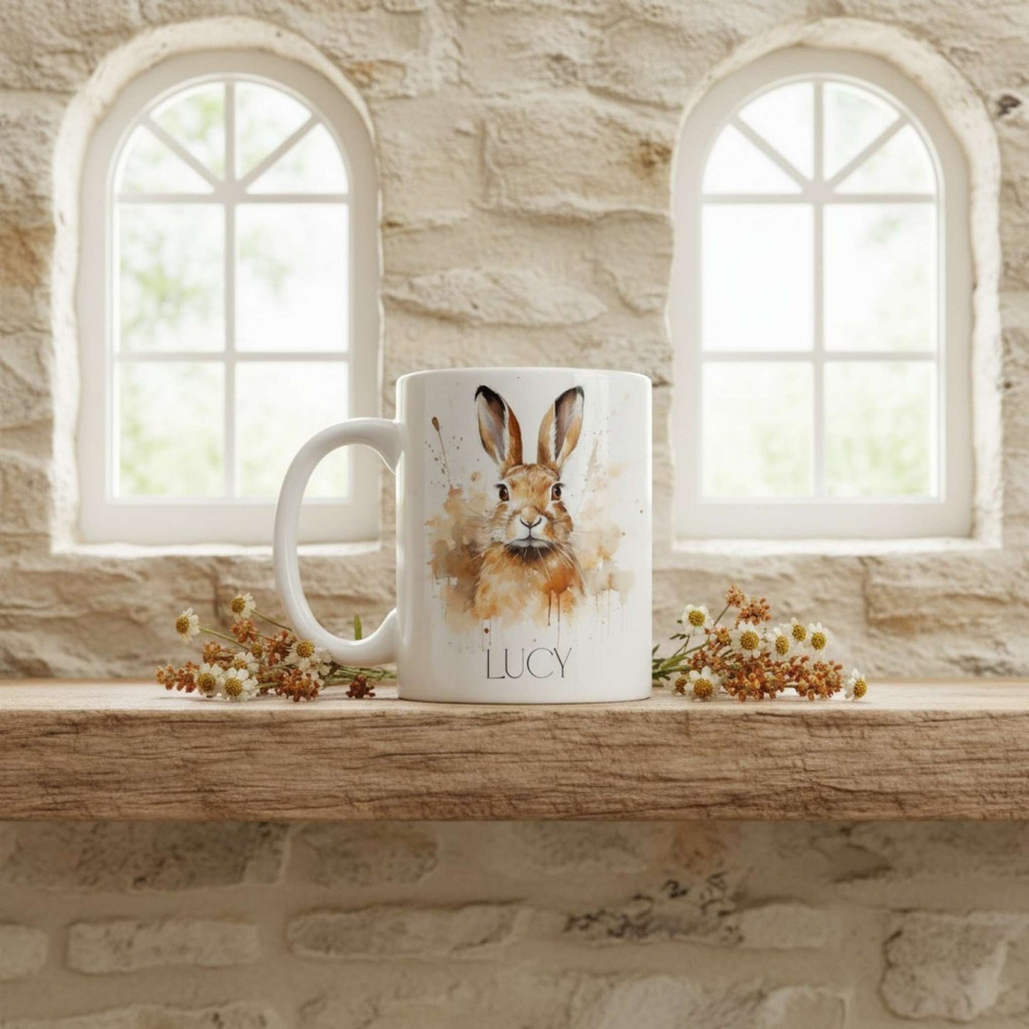 Mug with a hare design and 'Lucy' on a wooden shelf with stone wall and windows in the background