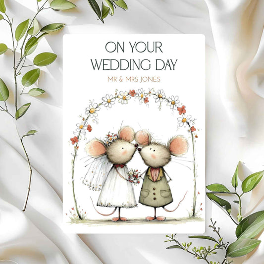 Wedding card with cartoon mice couple and 'On Your Wedding Day' text on a white background with green leaves.