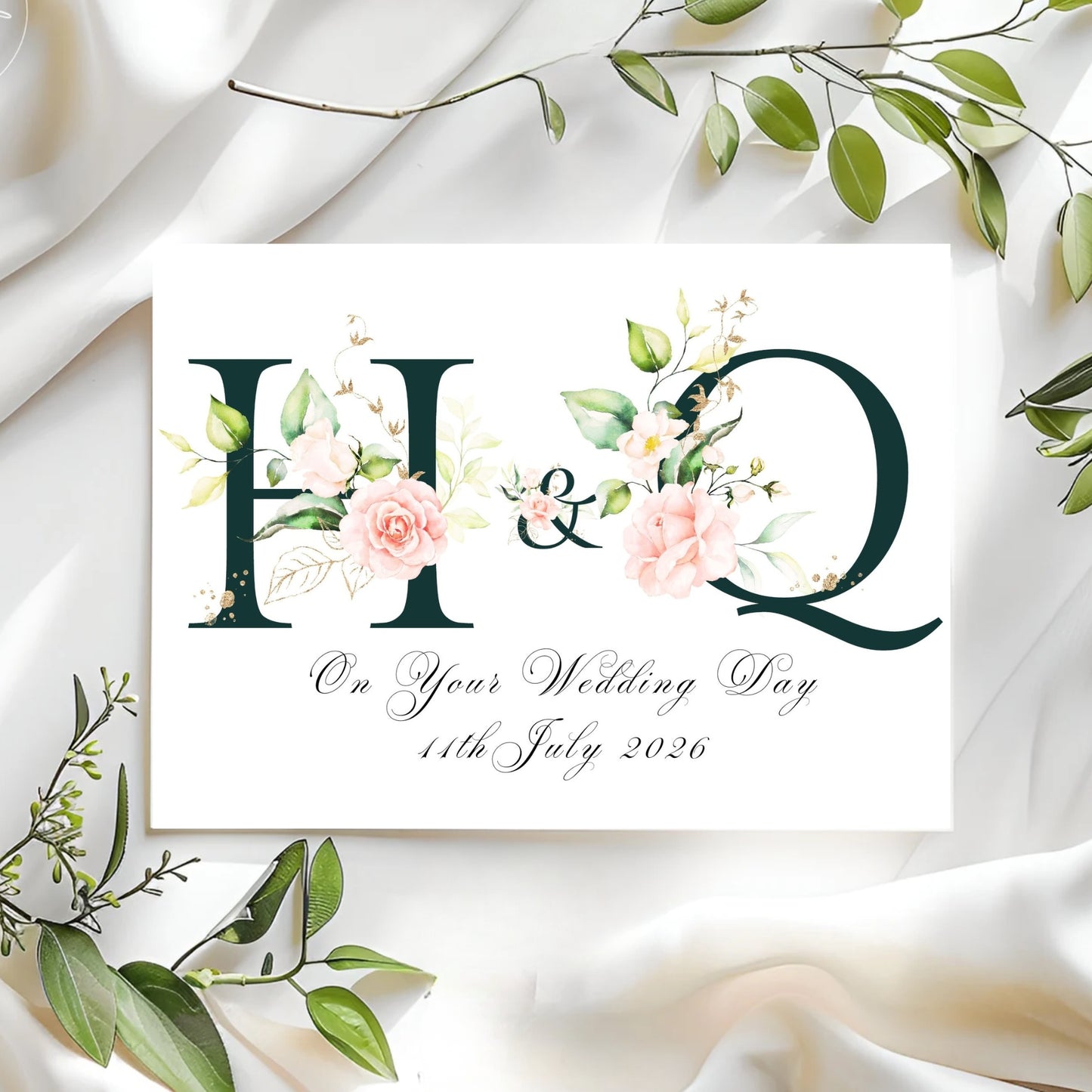 Initials personalised wedding card with floral initials and date on a white fabric background