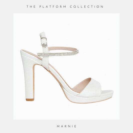 Ivory high-heeled bridal sandal with a platform sole on a light grey background, labelled 'Marnie'.