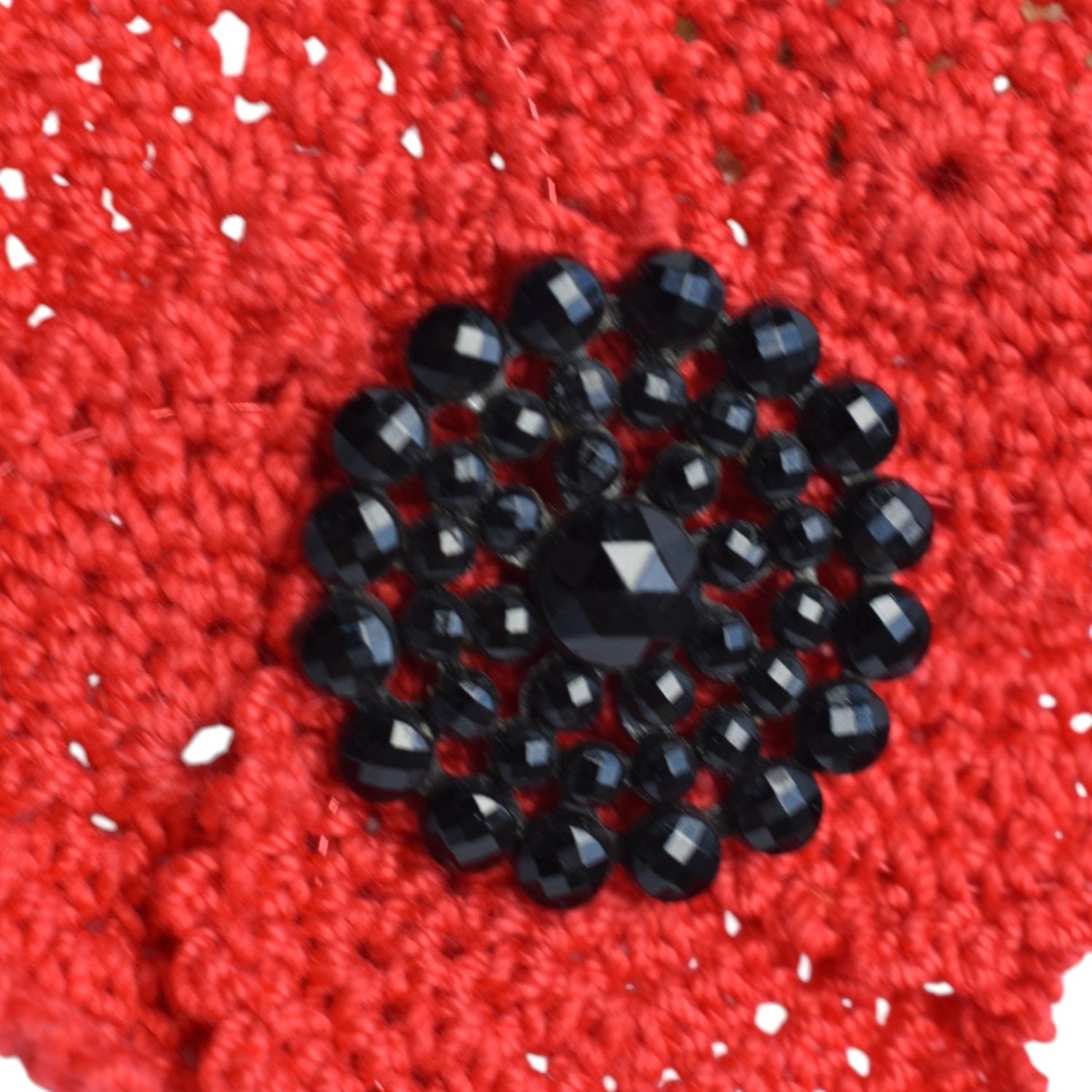 Red crocheted fabric with a button centre