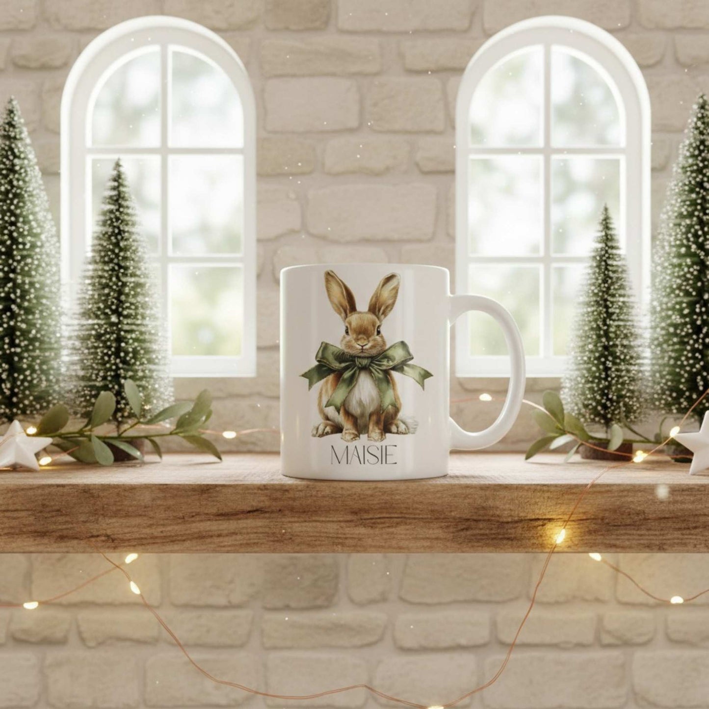 Mug with a hare design on a wooden shelf with decorative trees and lights.