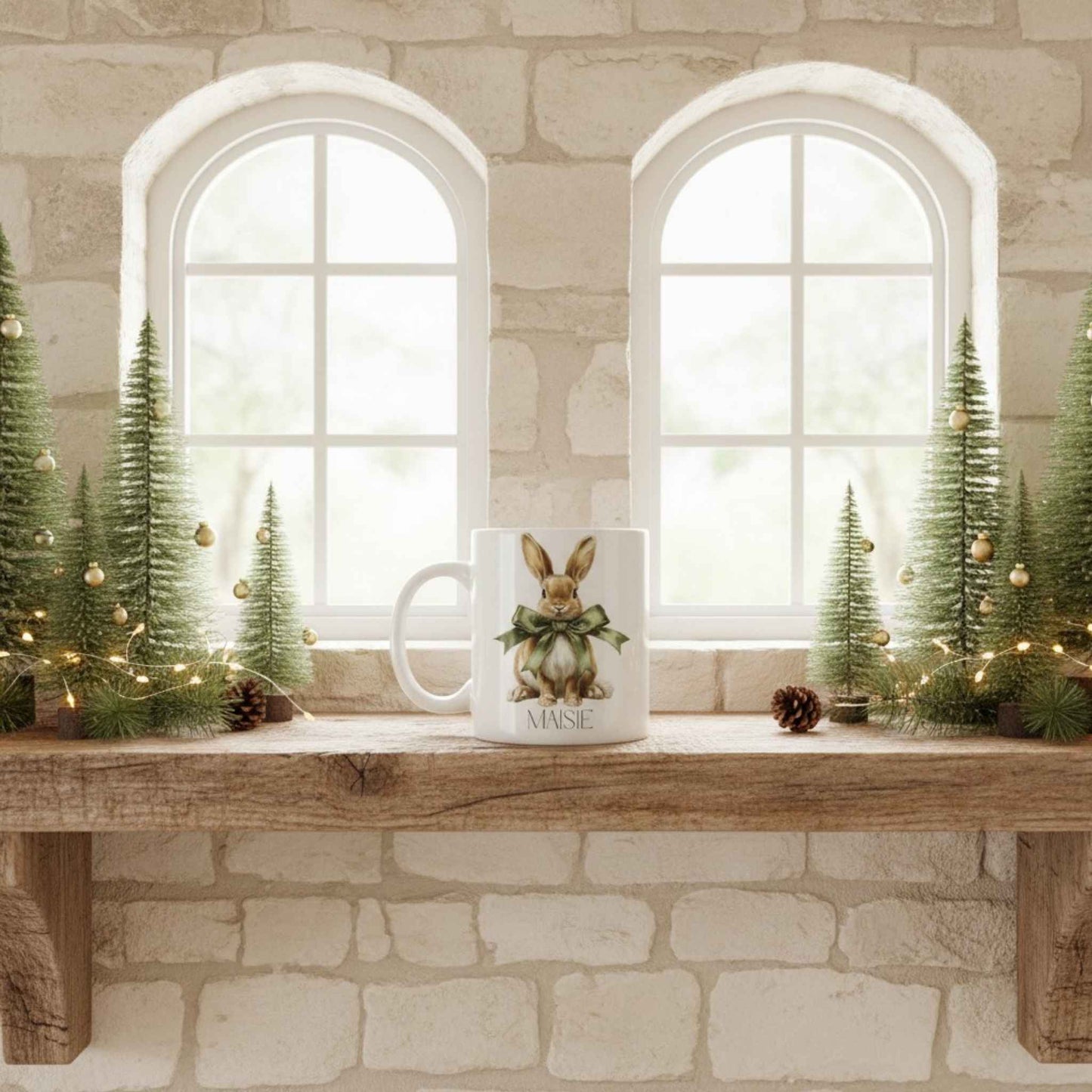 Decorative setup with Christmas trees, a mug with a hare design, and string lights on a stone wall background.