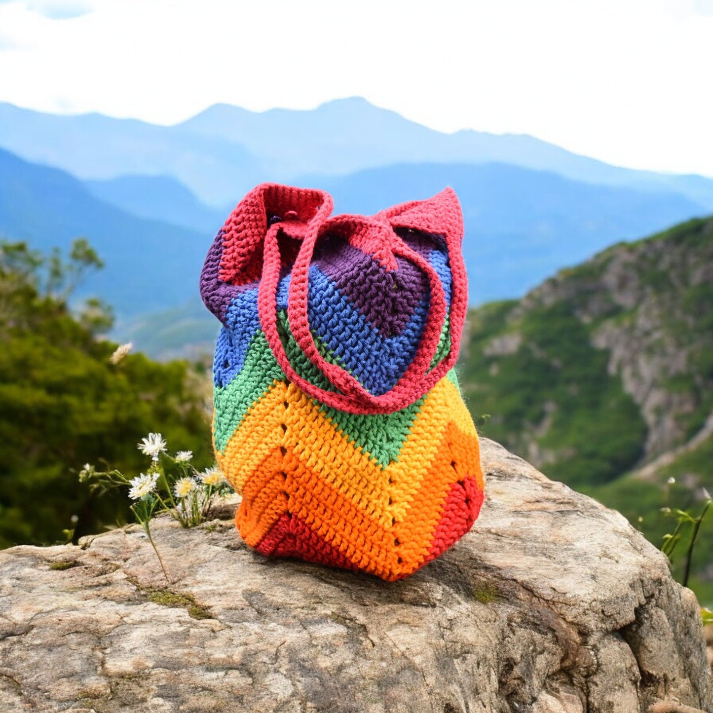 Colorful crochet bag  on a rock with a mountainous background