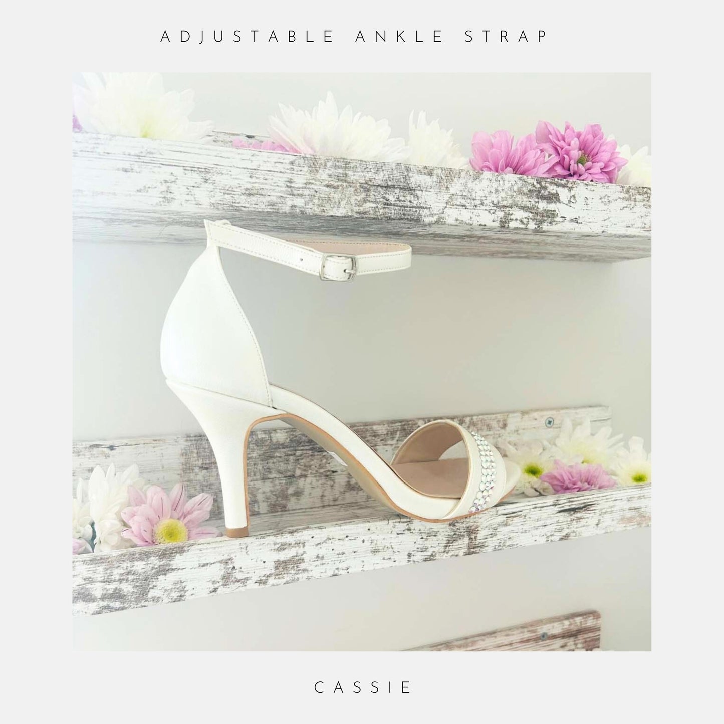 Ivory high-heeled shoe with adjustable ankle strap on a decorative shelf with flowers