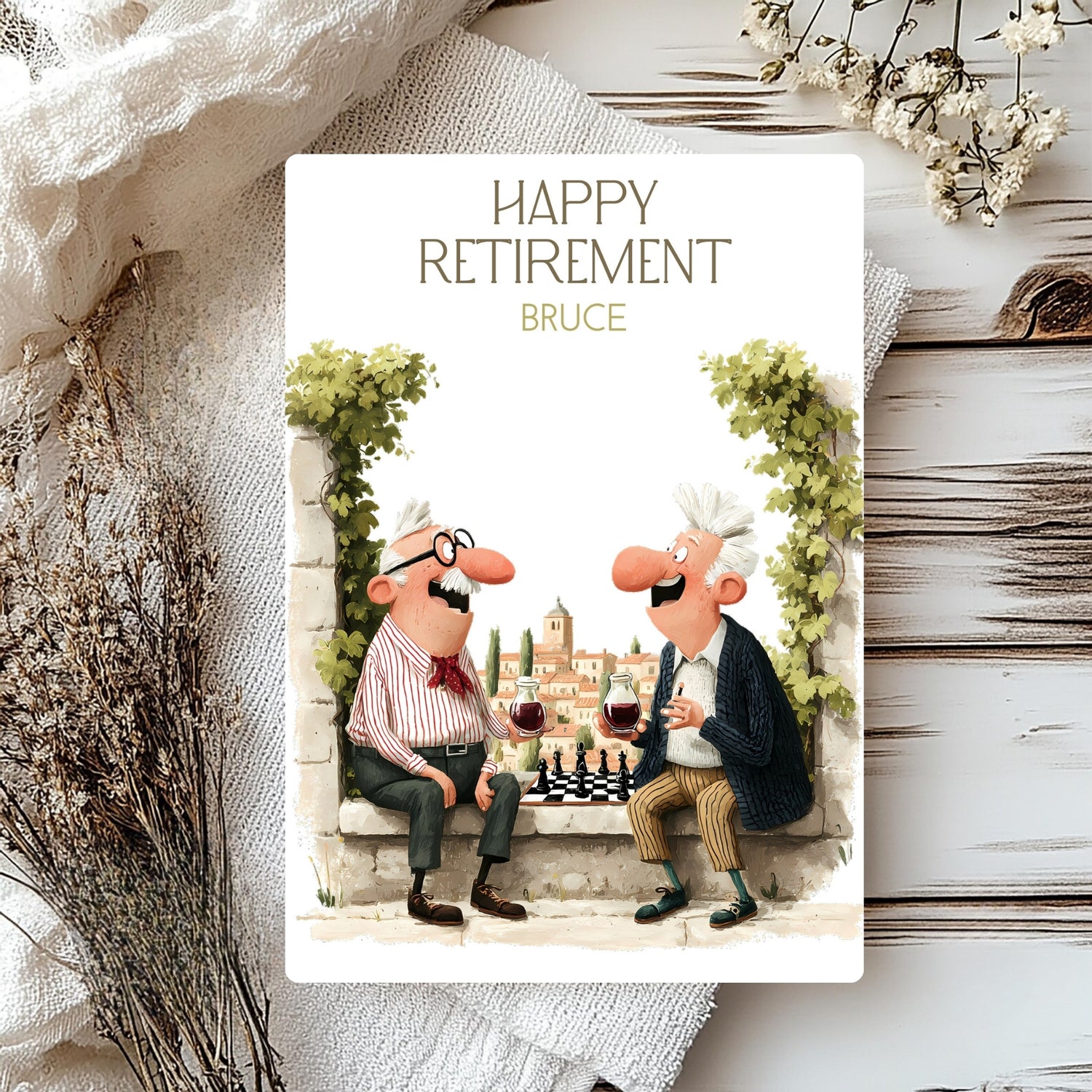 Happy Retirement card with cartoon characters enjoying wine and a game of chess, placed on a textured surface with decorative elements.