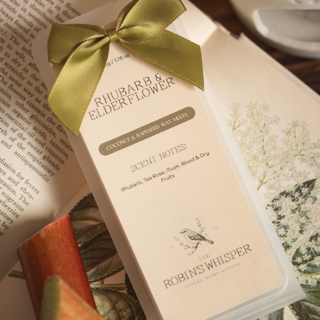 Product packaging of wax melts with a green ribbon on an open book