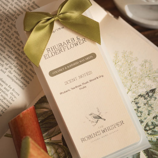 Product packaging of wax melts with a green ribbon on an open book