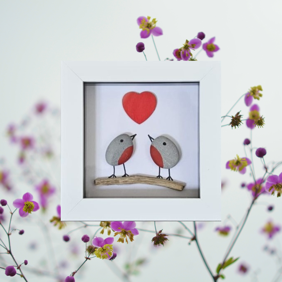 Framed artwork of two robins on a branch with a red heart above, surrounded by flowers.