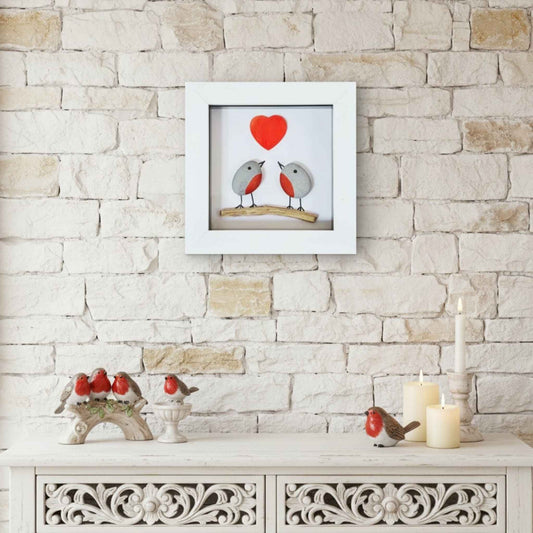 Framed artwork with two robins and a heart on a stone wall background