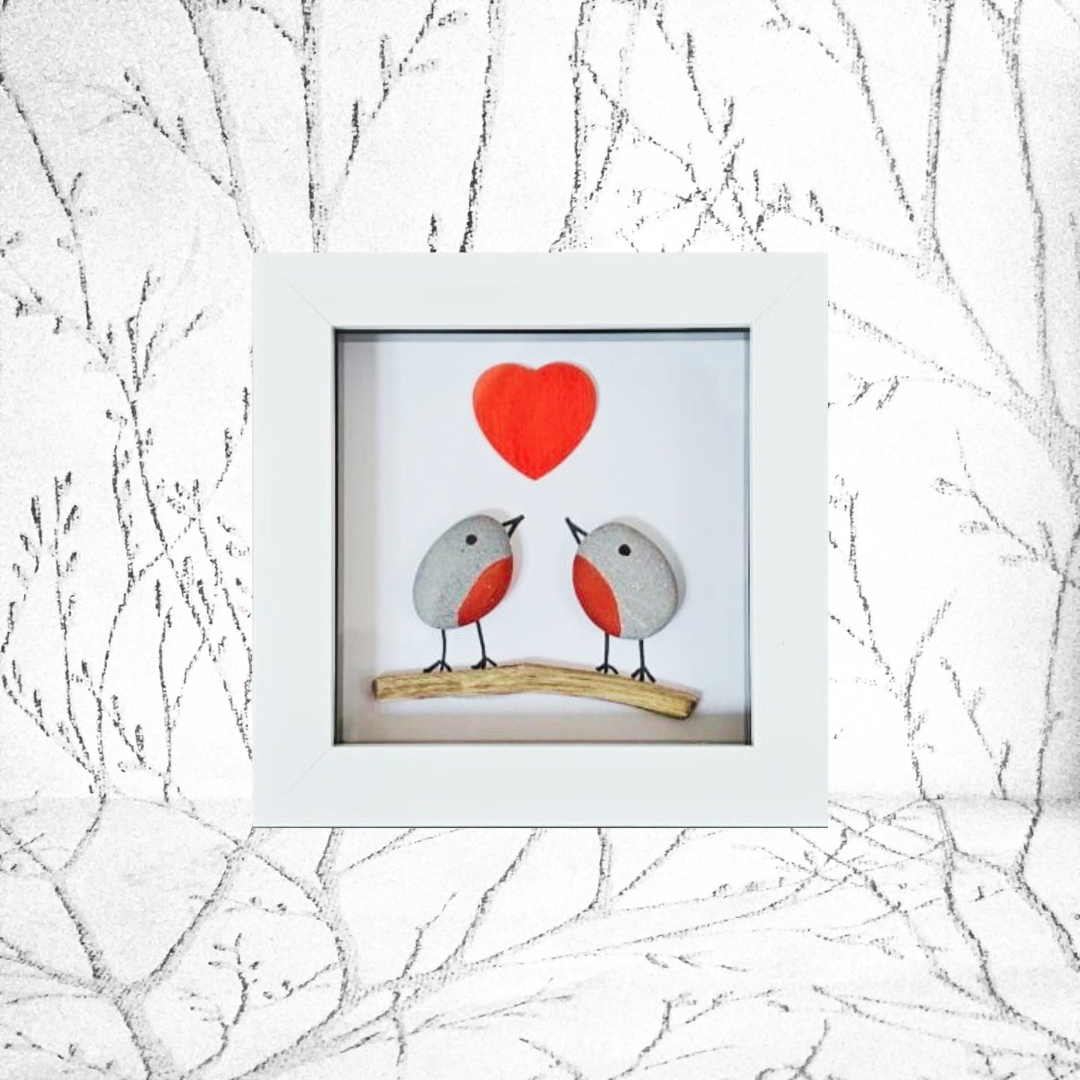 Framed artwork of two robins on a branch with a red heart against a white background