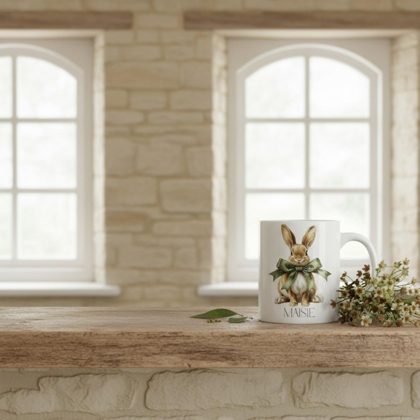 Mug with a hare design on a wooden surface in a room with stone walls and large windows.