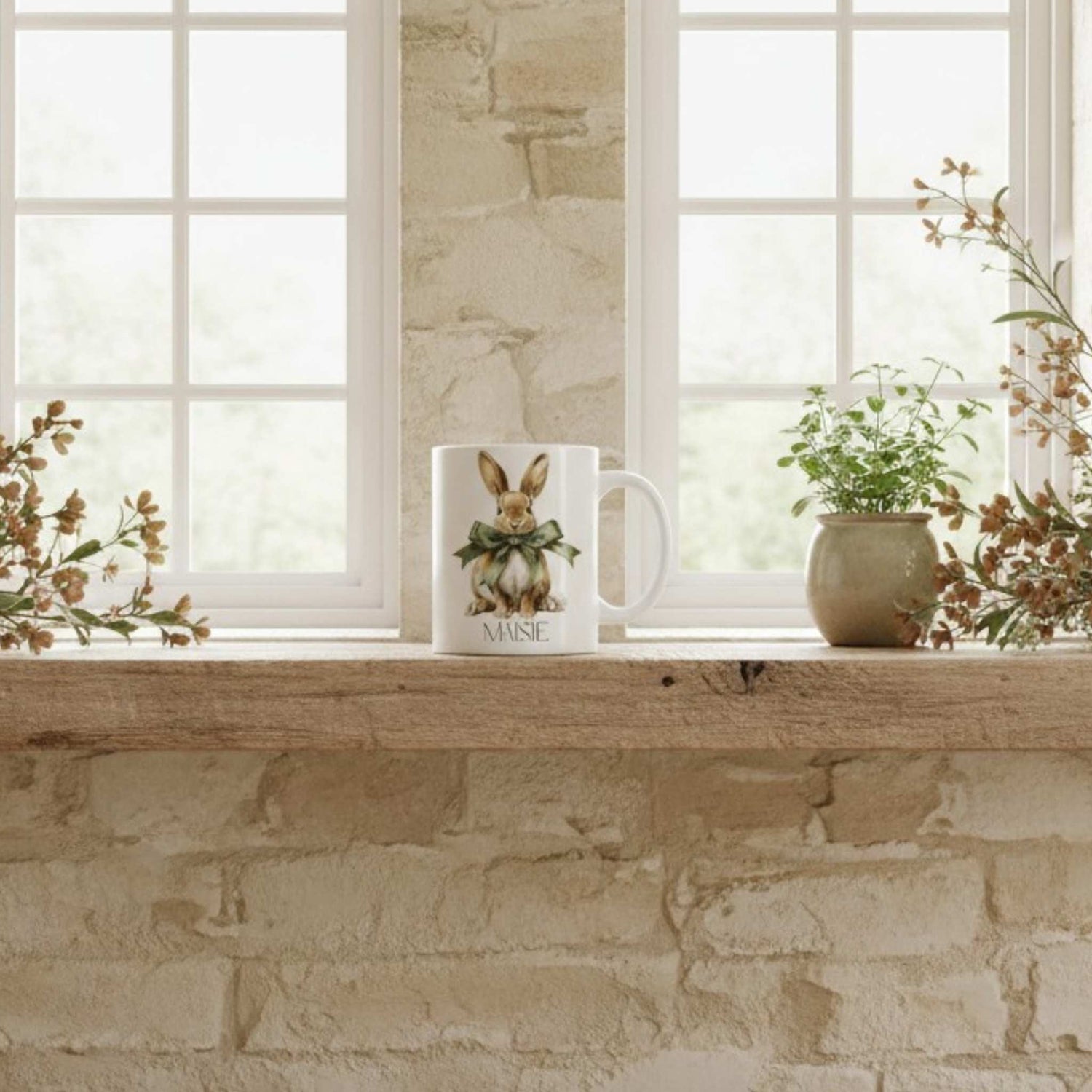 Mug with a hare design on a windowsill with plants and flowers.