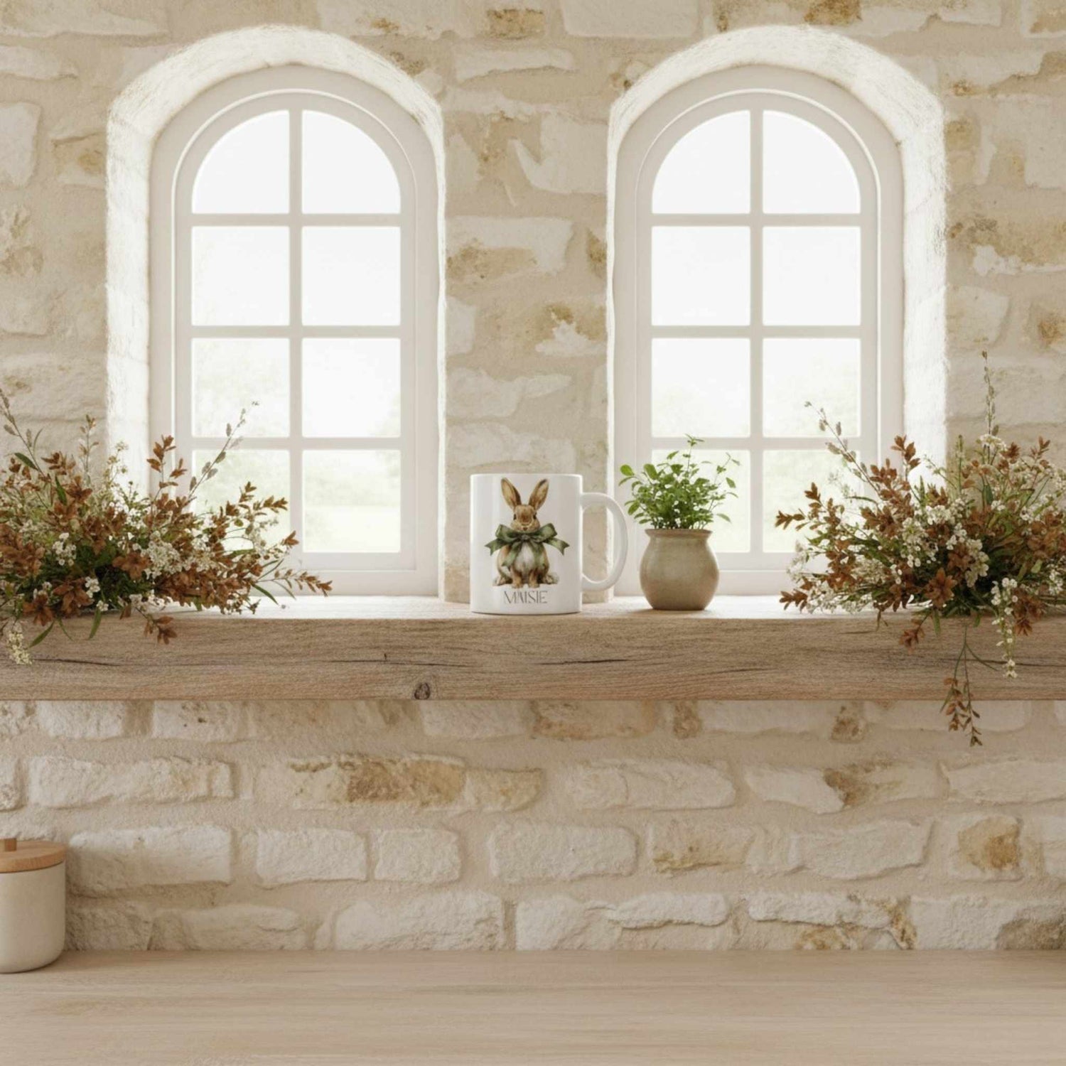 Mug on a shelf with dried flowers and pretty windows behind.