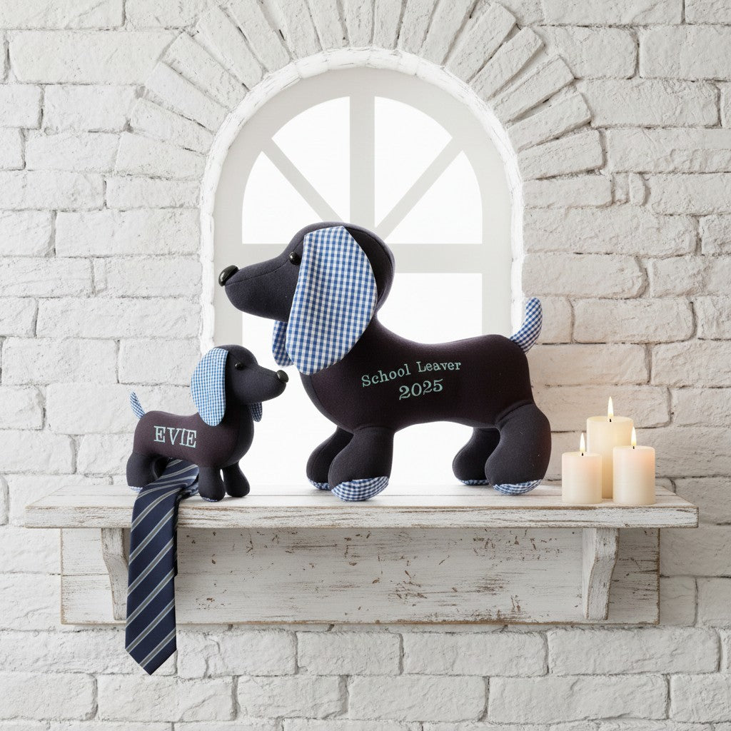 Two black plush dogs with checkered patterns on a white shelf against a stone wall.