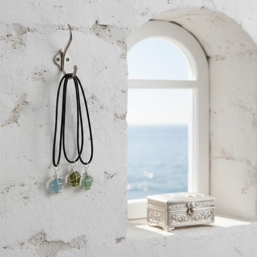 Sea glass turtle necklace with pendant on a hook against a window with a scenic view