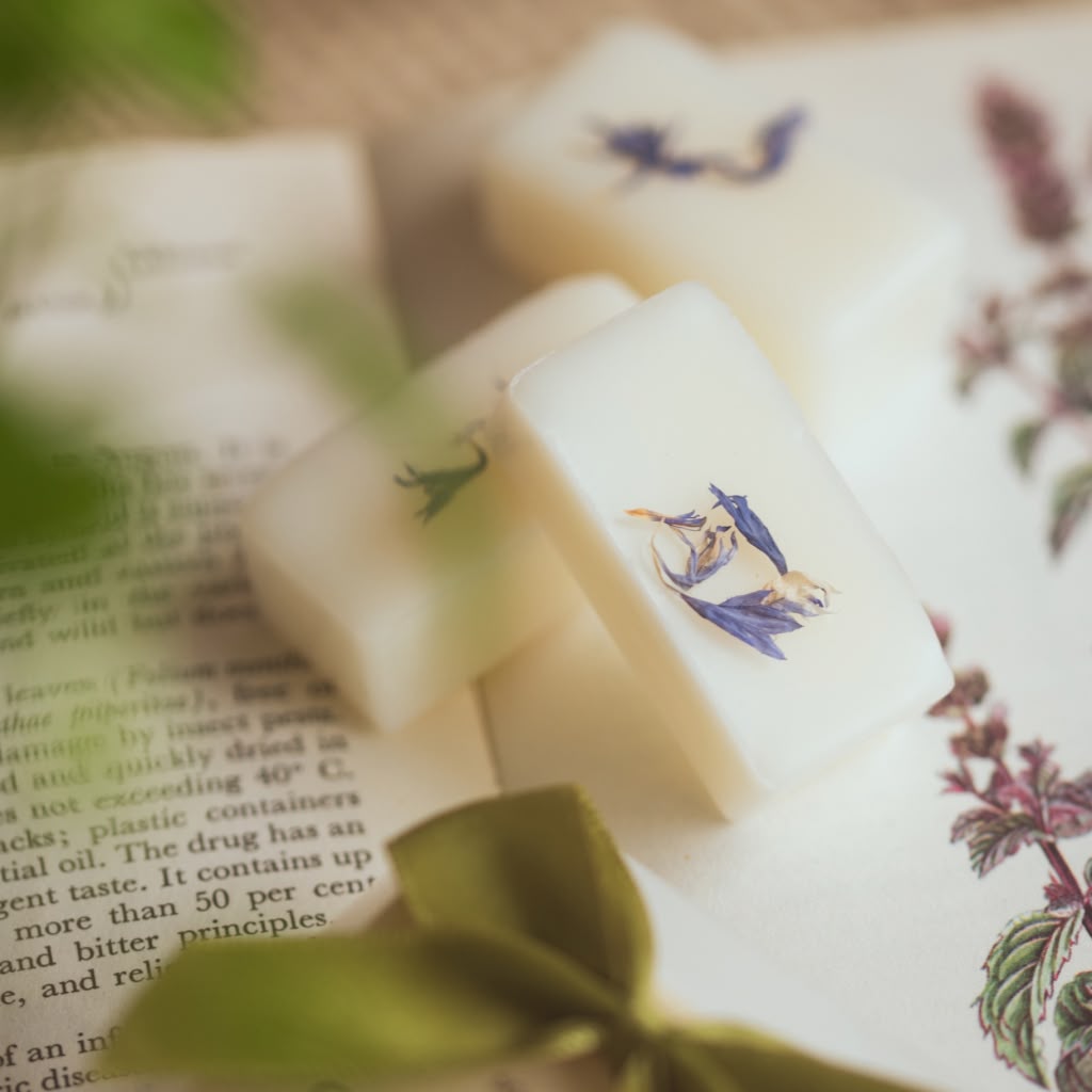 White wax melt bars with decorative designs on a book page