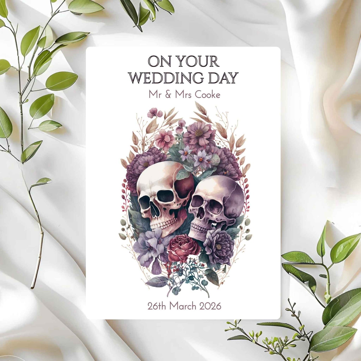 Wedding card with skulls and flowers on a white fabric background