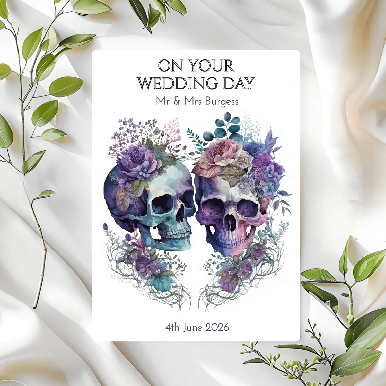 Personalised wedding card with skull and floral design on a white fabric background