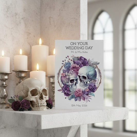 Decorative wedding card with skull design on a marble surface with candles