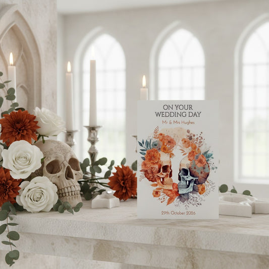 Wedding card with skull design on a decorative table with flowers and candles.