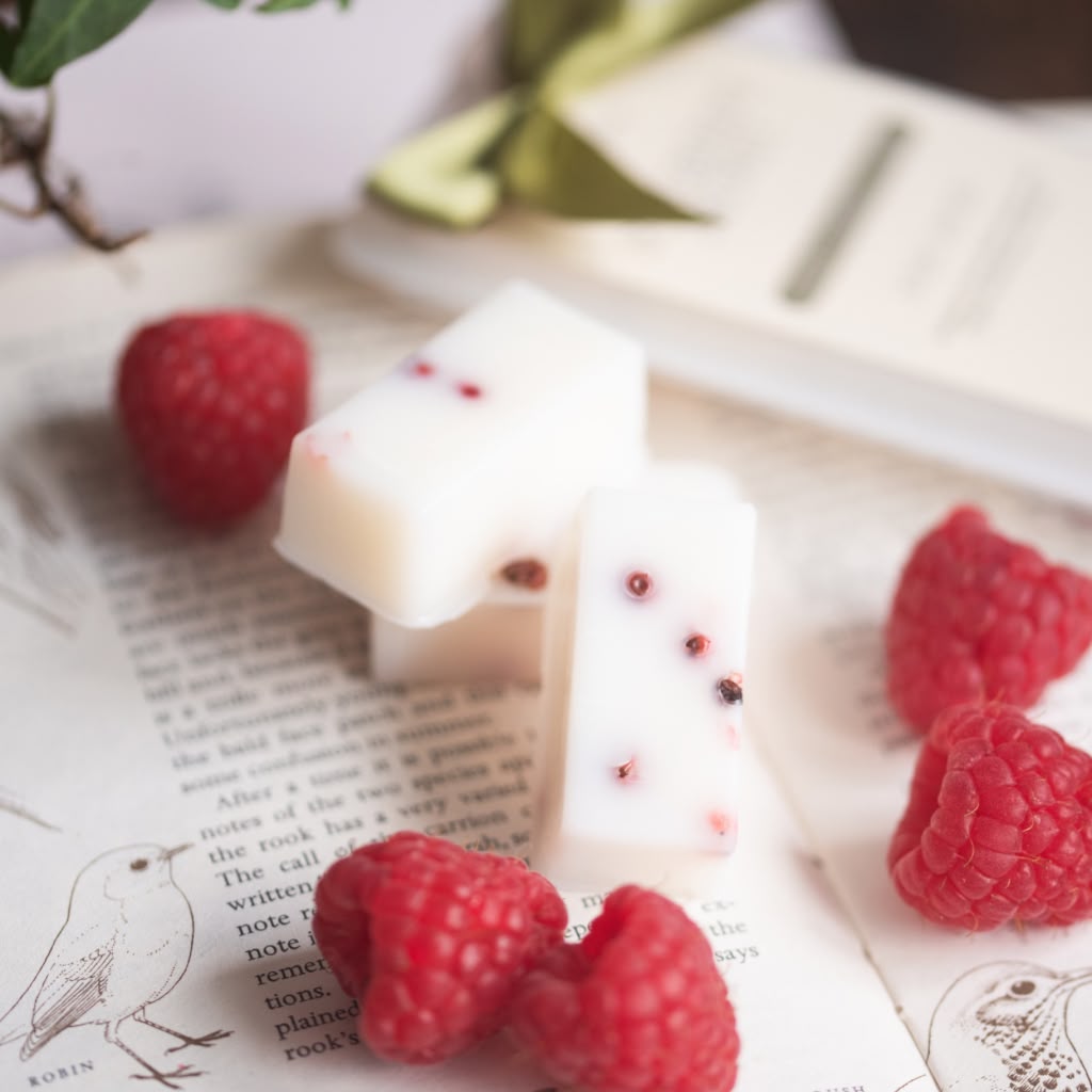 White wax melts with red berries on an open book